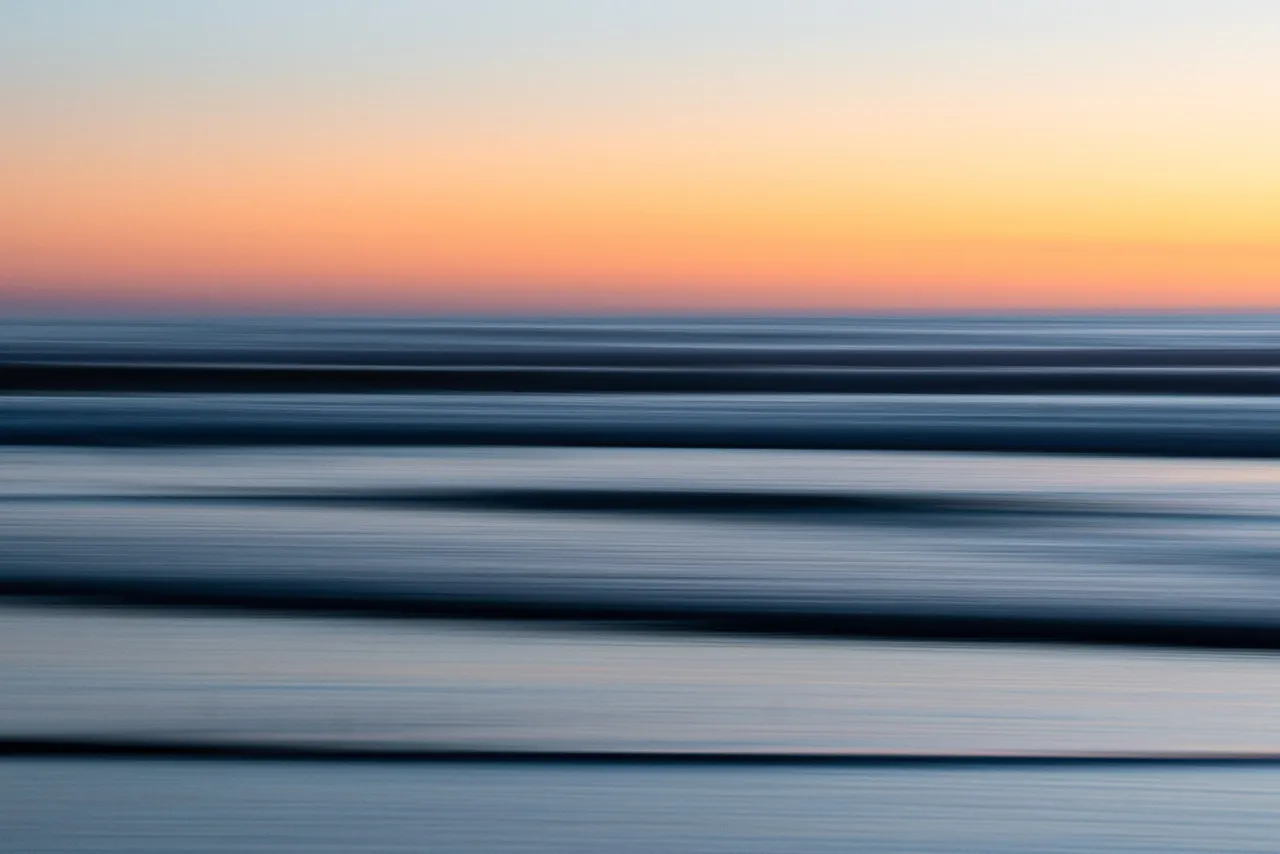 Soft orange light over the sea at dusk.